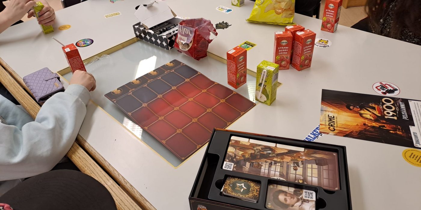 Kuvassa pöydällä erilaisia pelejä ja nuoria pöydän ympärillä testaamassa pelejä. Kuvaaja: Minna Kahala.