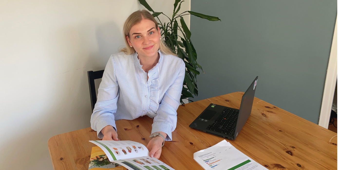 Meri Mustakallio esittelee ravitsemusopasta pöydän ääressä.