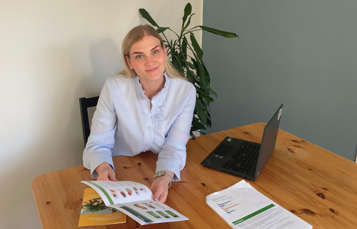 Meri Mustakallio esittelee ravitsemusopasta pöydän ääressä.