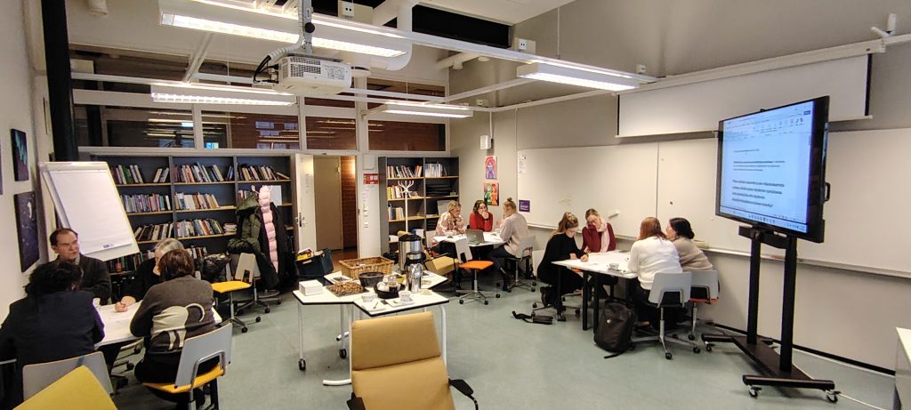 Yleiskuva luokkahuoneesta, jossa henkilöitä.