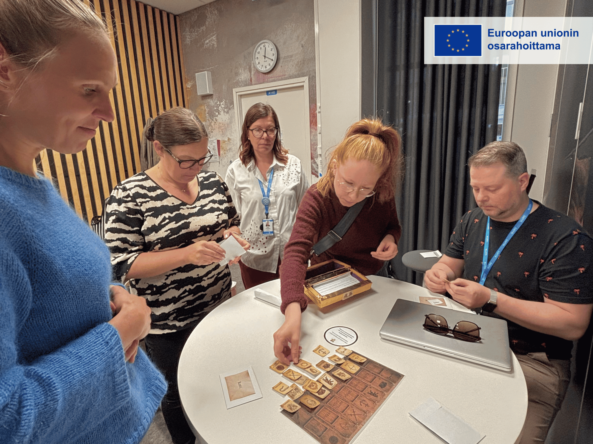 Diakin ja SAMKin tiimit virittäytyivät pelillistämistunnelmiin pelaamalla yhdessä hankkeen projektipäällikön Maija Rukkilan rakentamaa mysteeripeliä. Vasemmalta oikealle: Katri Huovinen, Maarit Harjanne, Marja Tomberg, Essi Nuotio ja Antti-Jussi Marjamäki. Kuva: Veera Iisakkala.